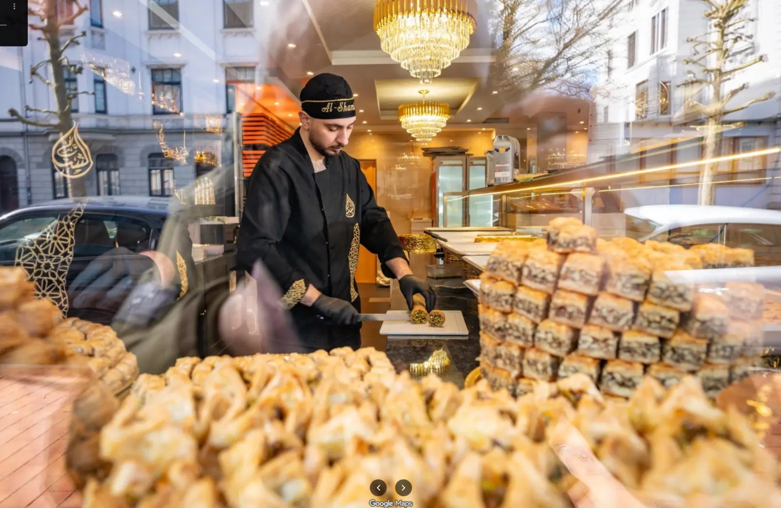 Mitarbeiter bei der Zubereitung hinter der gut gefüllten Auslage von Al-Shami Sweets